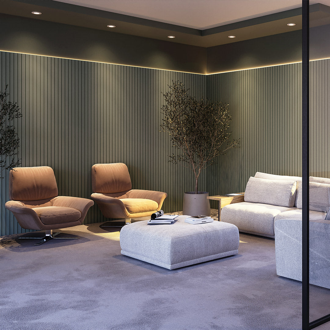 Sala de estar com poltronas acolchoadas e uma mesa de centro, as paredes utilizam painel ripado em EVA na cor verde.